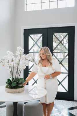 Realtor Alexis Bress arranging flowers in a new home, highlighting the personal touch buyers can expect with The Lex Group in Central Florida