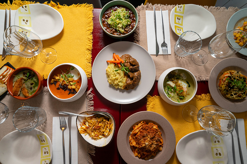 Top-down view of a restaurant table filled with diverse dishes and drinks